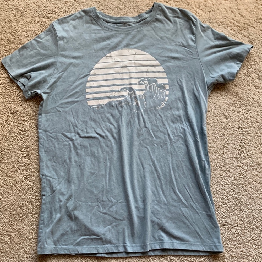 Light blue gray t-shirt shirt sleeve with wave graphic on it
